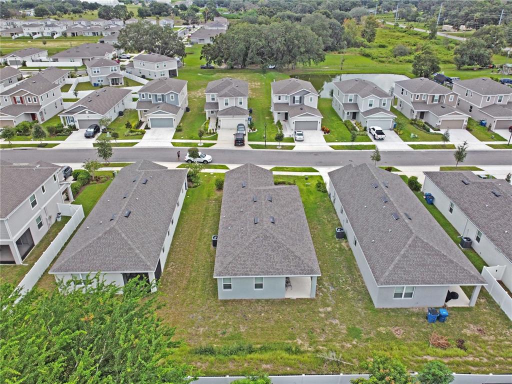 An aerial view shows several suburban houses with gray roofs and driveways in a neighborhood — 832 BLUE CREEK DRIVE, HAINES CITY, FL