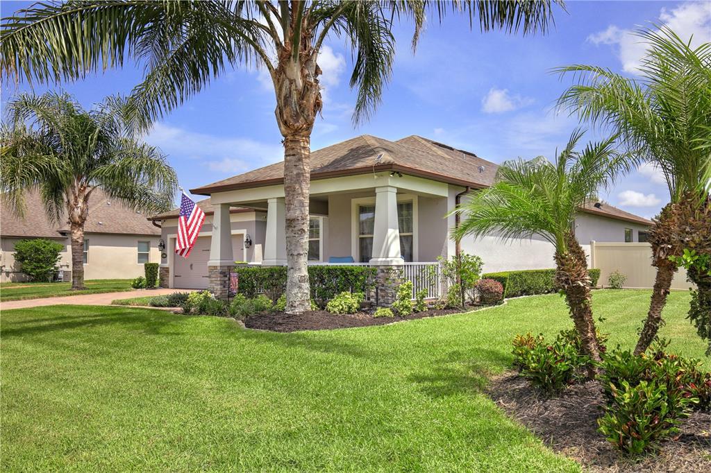 A single-story house with a covered front porch, stone accents, and palm trees in front — 3266 KAYAK WAY, ORLANDO, FL