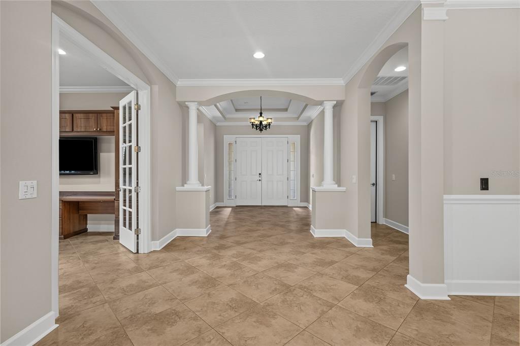 An entryway with tiled floors, white columns, a tray ceiling, and French doors to an office — 9913 WICKER PARK PLACE, PALMETTO, FL