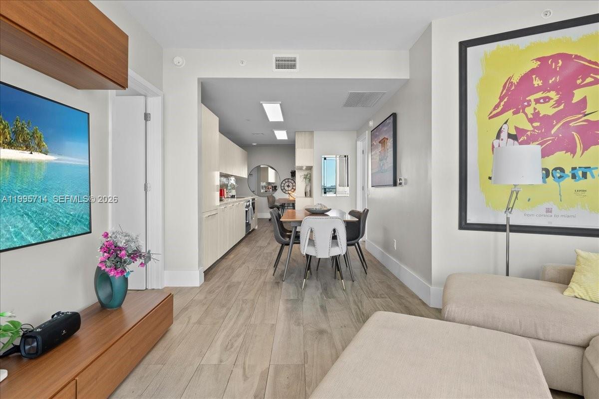 A modern living area flows into a dining space and kitchen with light wood flooring — 501 NE 31st St # 1201, Miami FL 33137, MIAMI, FL