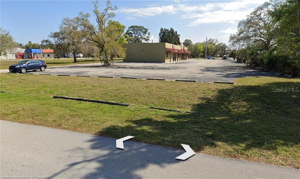 A large, paved parking lot sits in front of a single-story commercial building — 102 SW 14TH STREET, OKEECHOBEE, FL