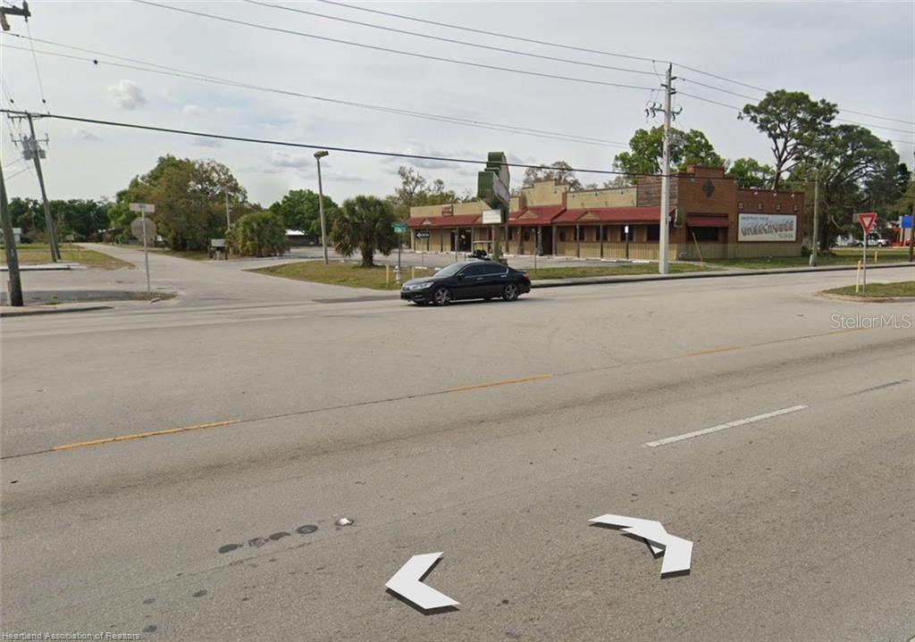A street-level view shows a commercial building with a parking lot and a black car — 102 SW 14TH STREET, OKEECHOBEE, FL