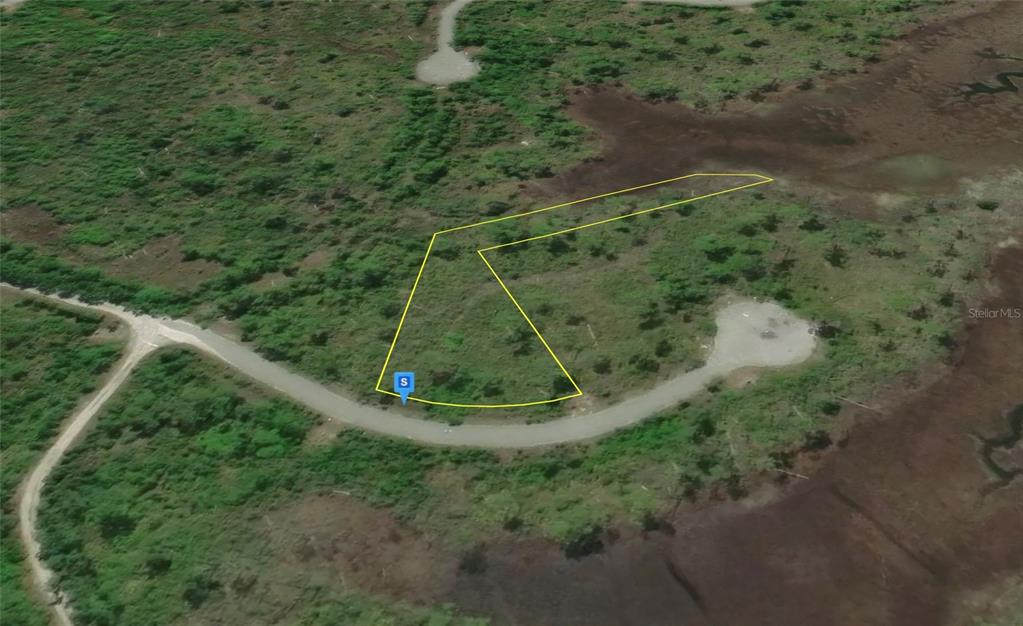 An aerial view shows a vacant, irregularly shaped lot outlined in yellow near a road — 2706 STING RAY ROAD, PANAMA CITY, FL
