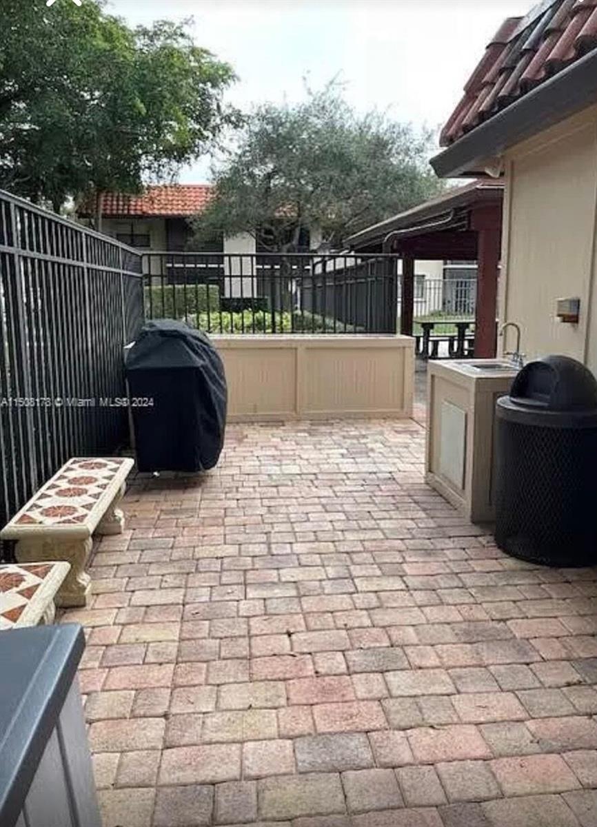 A paved patio features a grill, a small outdoor sink, and a stone bench — 15813 W Waterside Circle # 206, Sunrise FL 33326, SUNRISE, FL