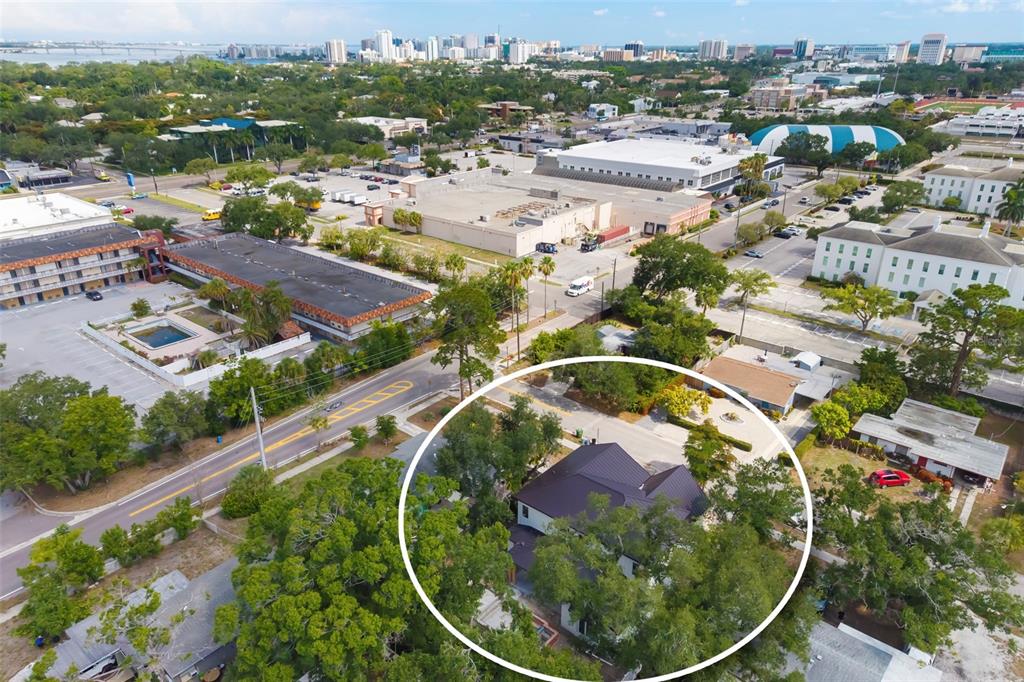 An aerial view shows a house with a dark roof surrounded by trees and buildings — 2114 FLOYD STREET, SARASOTA, FL