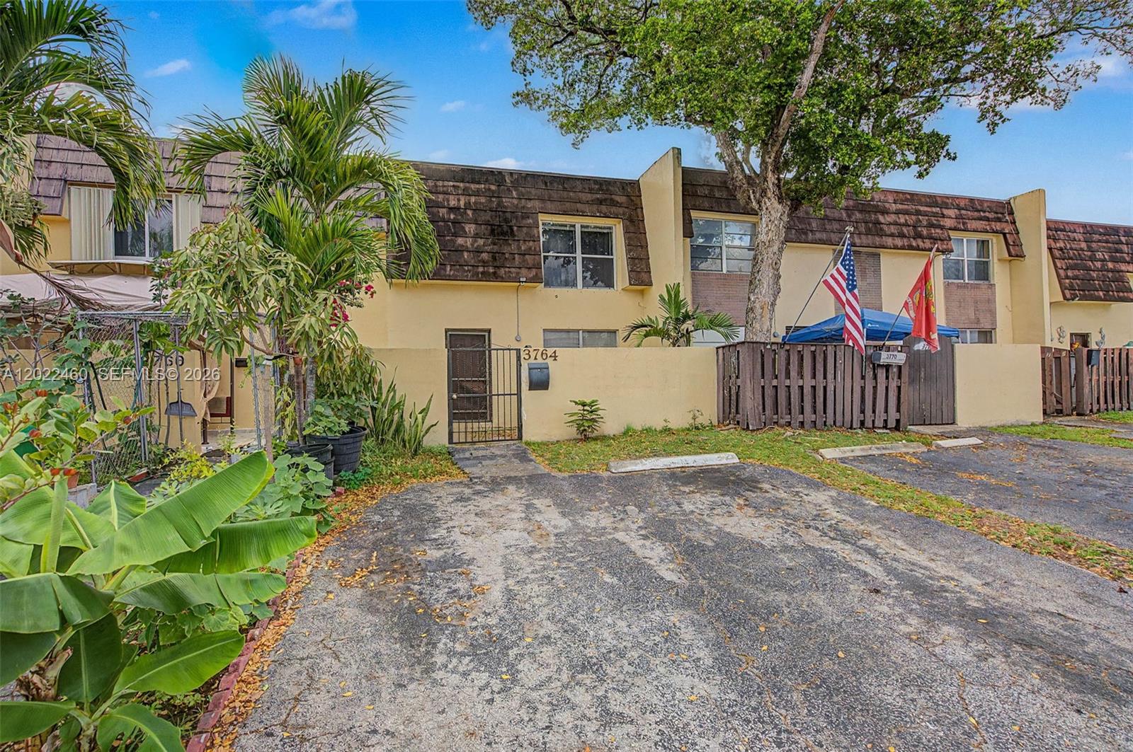 A two-story townhouse exterior features a paved parking space, a gated entrance, and landscaping — 3764 SW 60th Ter # 15, Davie FL 33314, DAVIE, FL