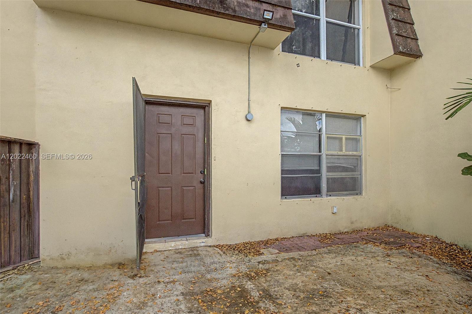 An exterior view shows a brown door, a window, and a concrete patio area — 3764 SW 60th Ter # 15, Davie FL 33314, DAVIE, FL
