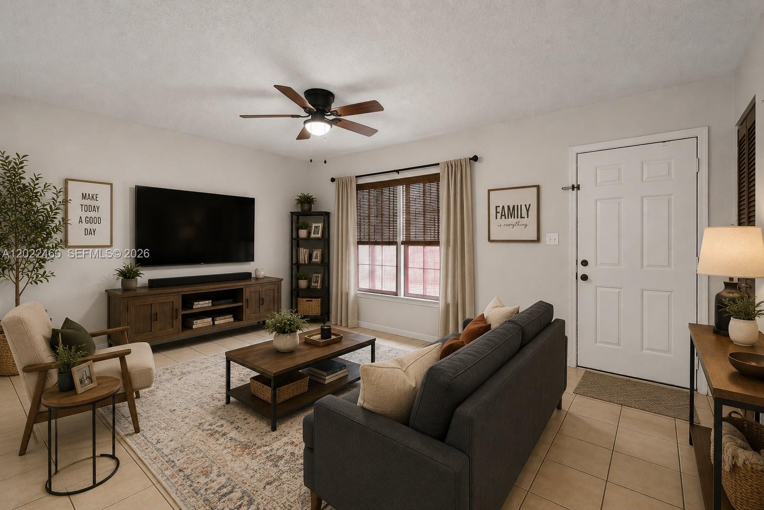A living room features a dark sofa, wood media console, ceiling fan, and tiled flooring — 3764 SW 60th Ter # 15, Davie FL 33314, DAVIE, FL