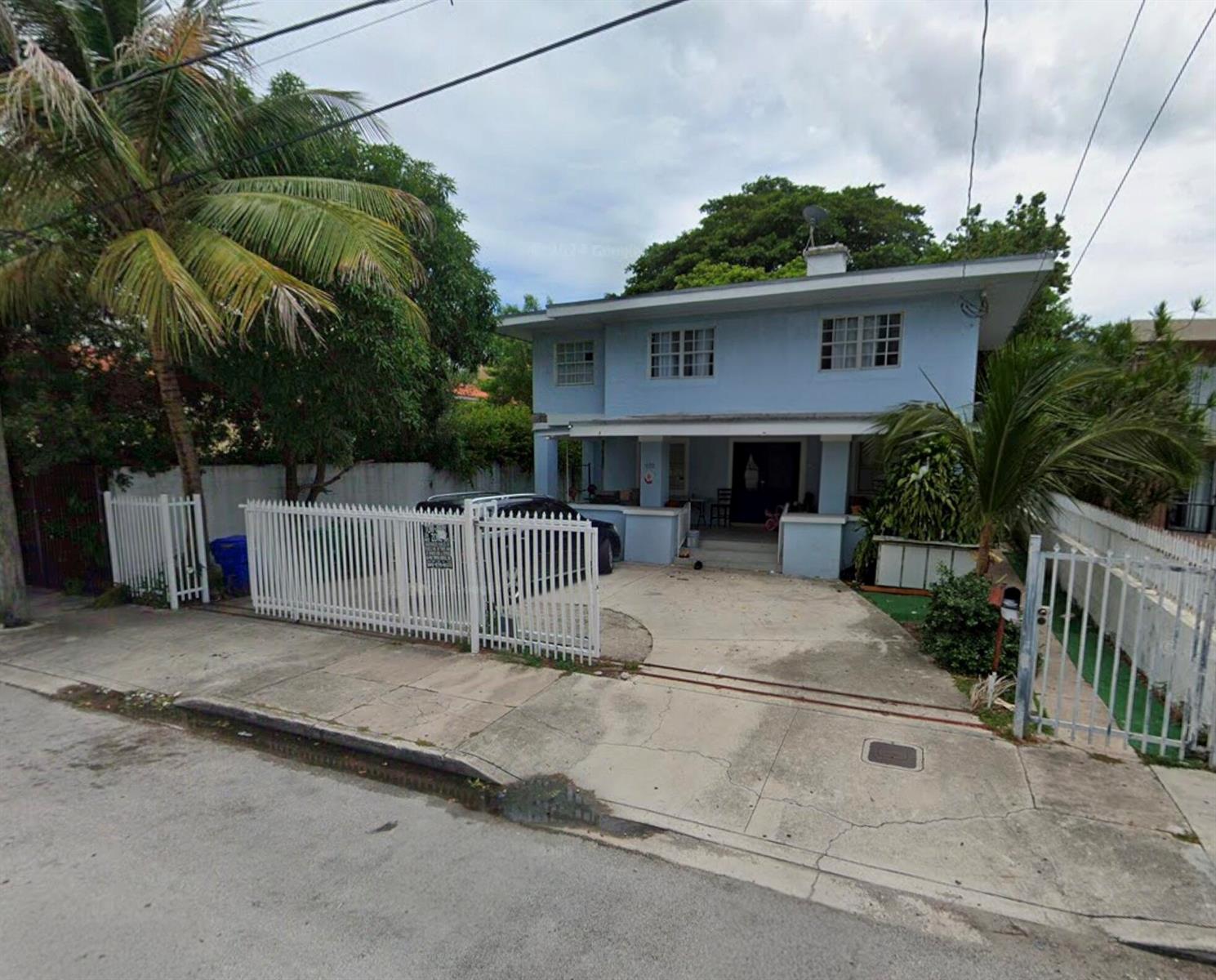 A two-story light blue house with a white fence and a concrete driveway — 652 NW 1st Street, Miami FL 33128, MIAMI, FL