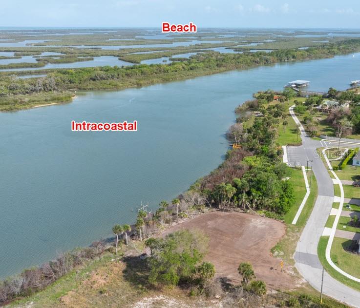 An aerial view shows a vacant waterfront lot adjacent to a road and the Intracoastal — 183 & 185 JONES FISH CAMP ROAD, EDGEWATER, FL