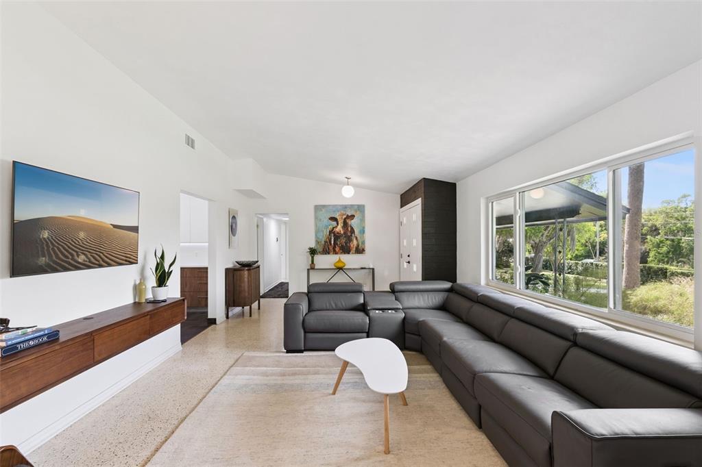 A living room features a large gray sectional sofa, a white coffee table, and a television — 10426 LAKESHORE DRIVE, CLERMONT, FL