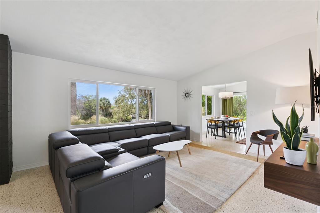 A living room with a large gray sectional sofa, a white coffee table, and dining area — 10426 LAKESHORE DRIVE, CLERMONT, FL