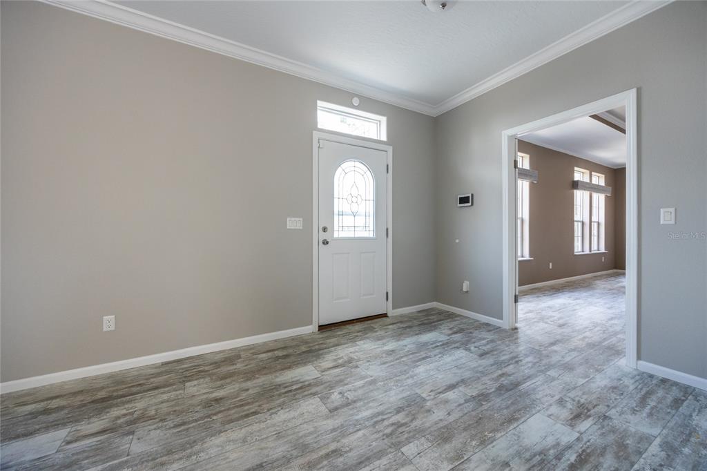 An entryway with gray walls, wood-look tile flooring, and a white front door with glass — 6671 SW 128TH LANE, LAKE BUTLER, FL
