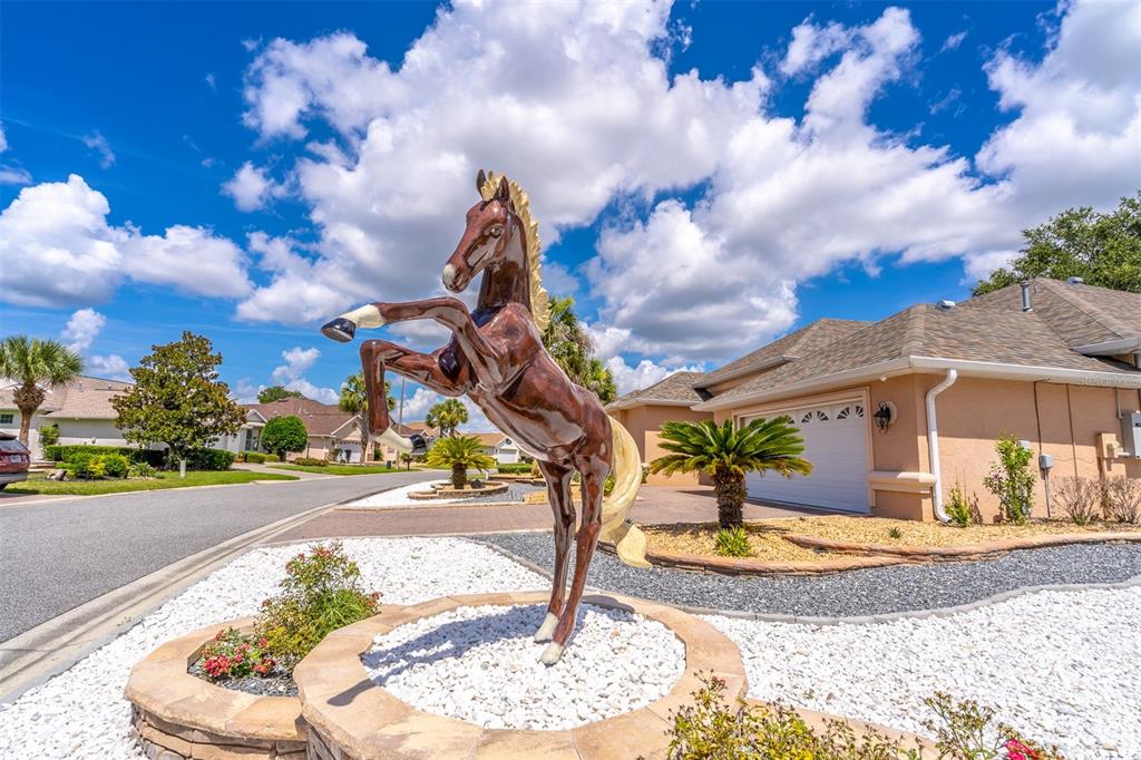 A large brown horse statue stands in a landscaped front yard near a suburban house — 8508 SW 84TH LOOP, OCALA, FL
