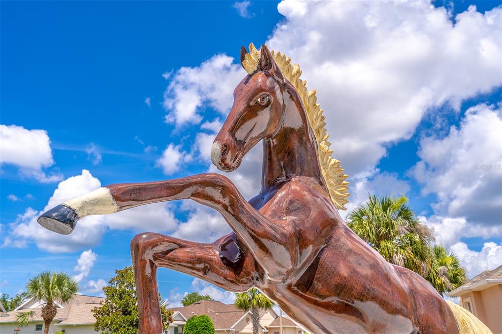 A large, brown, rearing horse statue stands outdoors against a bright blue sky — 8508 SW 84TH LOOP, OCALA, FL