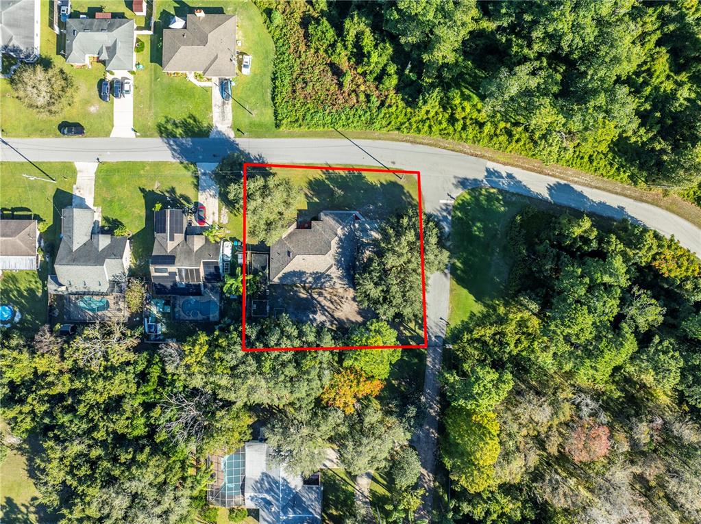 An aerial view shows a house with a red boundary line on a wooded lot — 1191 S BRICKELL DRIVE, DELTONA, FL