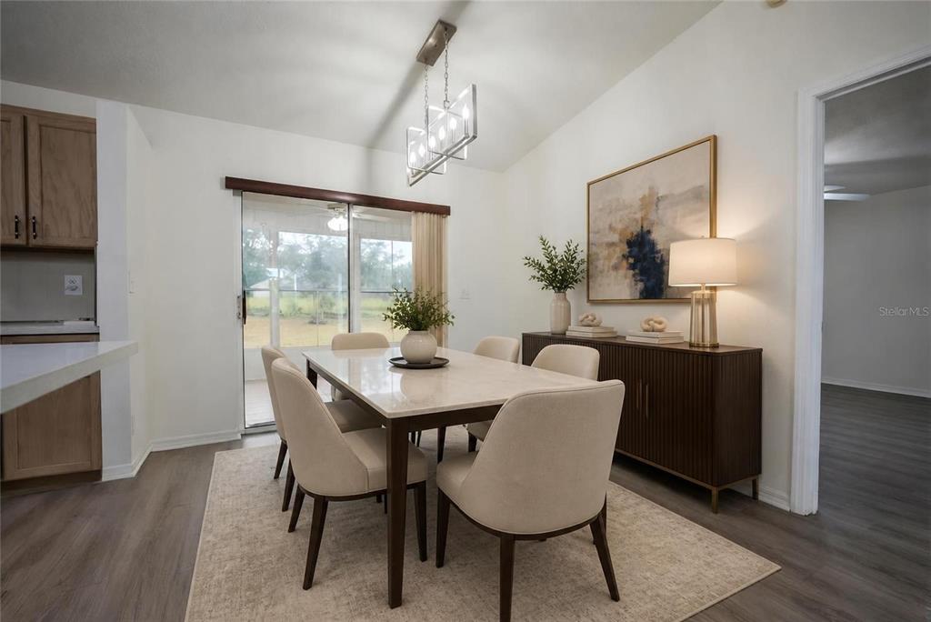 A dining room features a marble-topped table, upholstered chairs, a sideboard, and sliding glass doors — 10452 SW 62ND TERRACE ROAD, OCALA, FL
