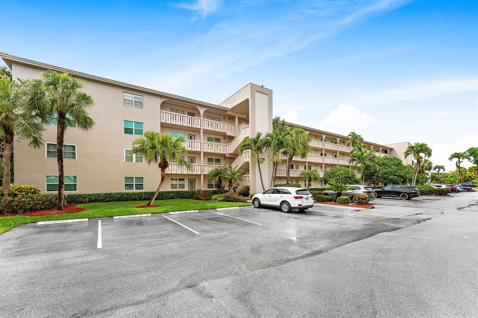 A multi-story apartment building with a parking lot and palm trees in front — 3301 Aruba Way # C1, Coconut Creek FL 33066, COCONUT CREEK, FL