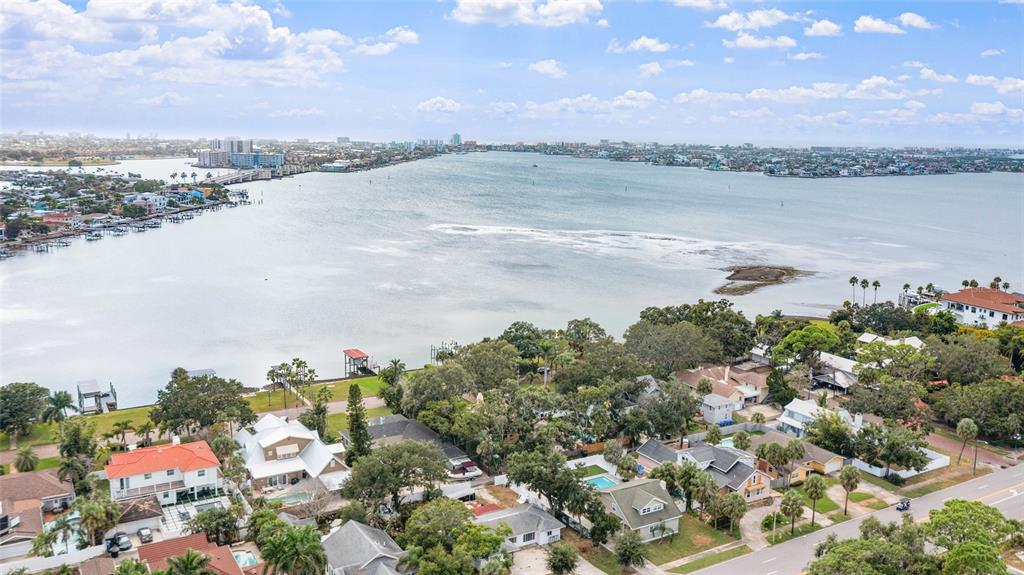 An aerial view shows a coastal residential neighborhood bordering a large bay with a bridge — 311 SUNSET DRIVE N, ST PETERSBURG, FL