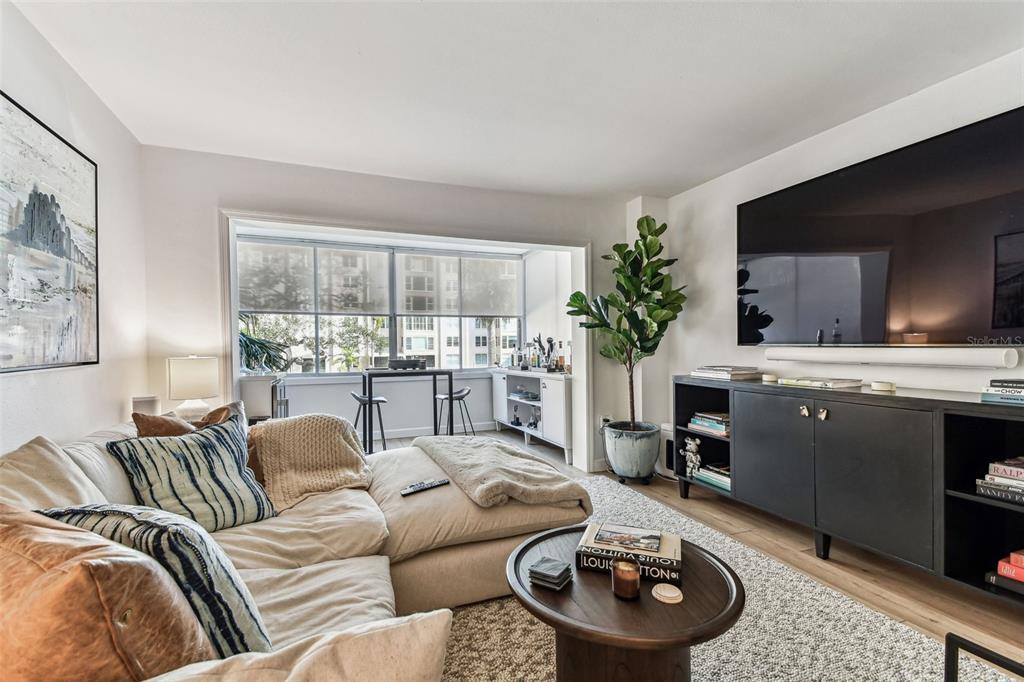 A large swimming pool sits on a paved patio between two multi-story apartment buildings — 620 EDGEWATER DRIVE UNIT 204, DUNEDIN, FL