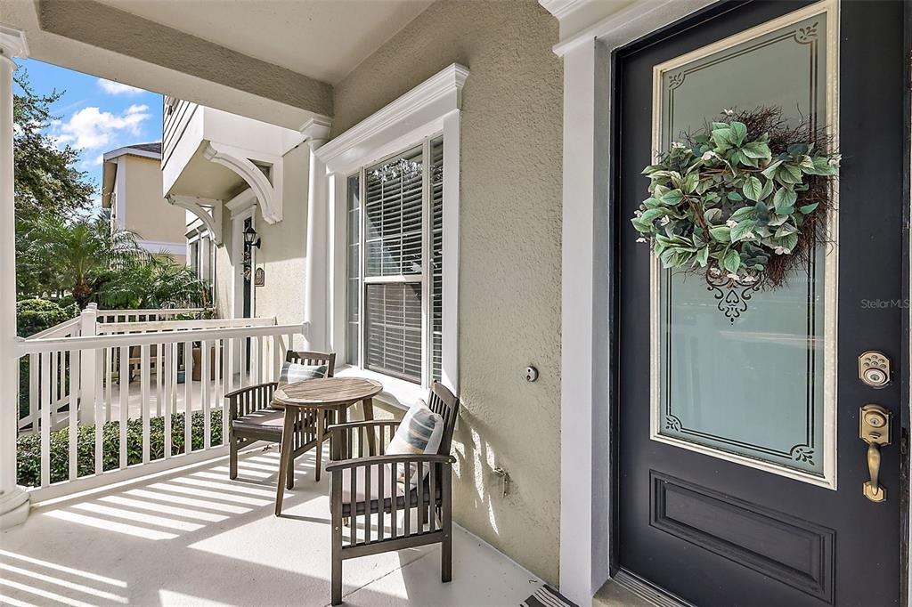 A front porch features a dark door with a wreath, a chair, and decor — 412 BLUE BAYOU LANE, WINTER SPRINGS, FL