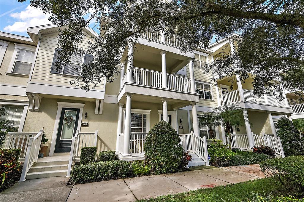 A covered front porch features two wooden chairs, a small table, and a dark door — 412 BLUE BAYOU LANE, WINTER SPRINGS, FL