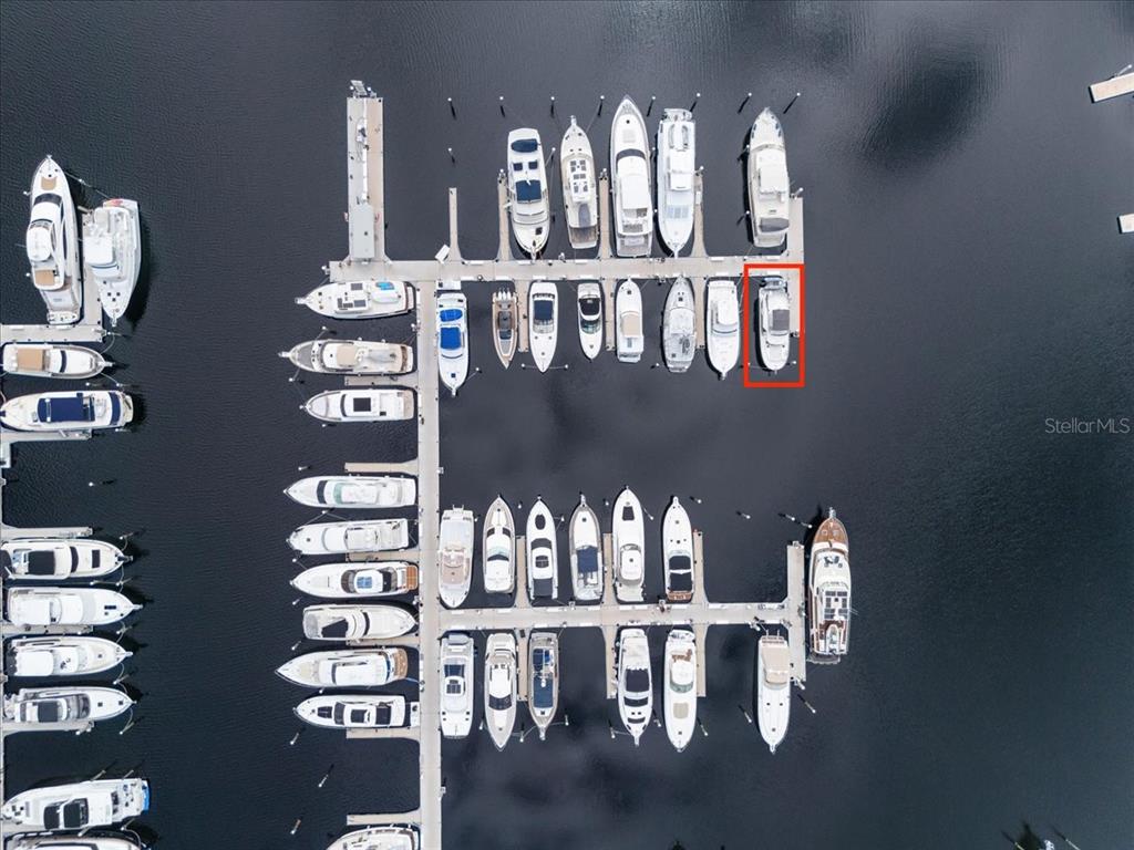 An aerial view shows a marina with numerous boats docked in slips — 102 RIVIERA DUNES WAY UNIT S-36, PALMETTO, FL