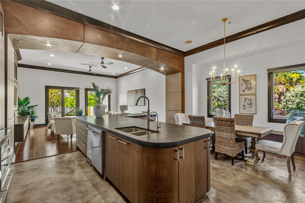 A kitchen with a large island and dark countertops opens into a dining area — 1008 PASEO DEL RIO NE, ST PETERSBURG, FL