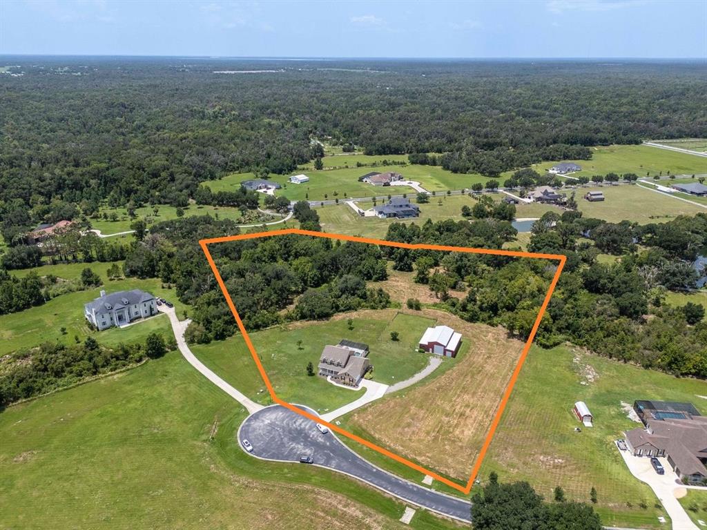 An aerial view shows a house and detached garage on a large, partially wooded lot — 8703 ALAFIA HILLS DRIVE, PLANT CITY, FL