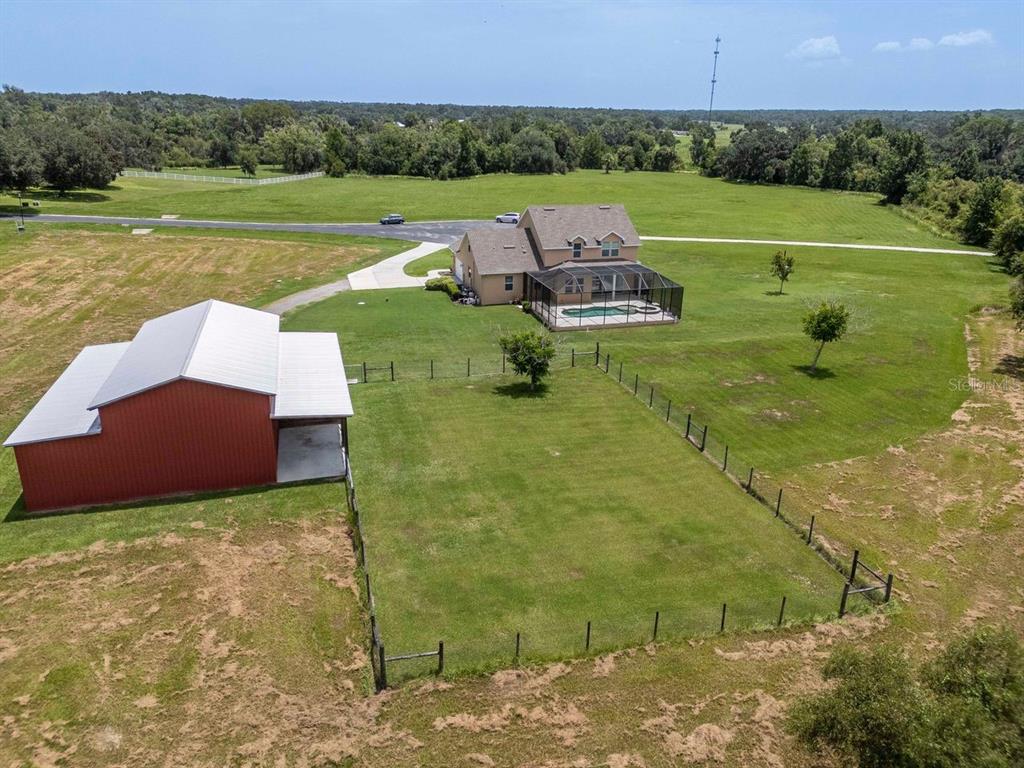 An aerial view shows a house with a pool and a red barn on land — 8703 ALAFIA HILLS DRIVE, PLANT CITY, FL