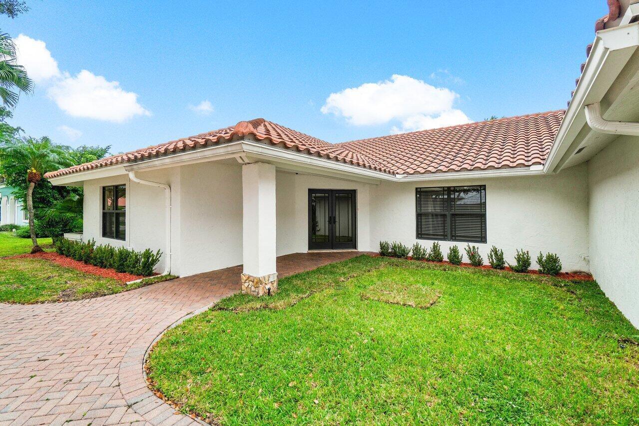 A single-story house exterior features a tiled roof, white stucco walls, and a brick walkway — 2150 NW 23rd Way, Boca Raton FL 33431, BOCA RATON, FL