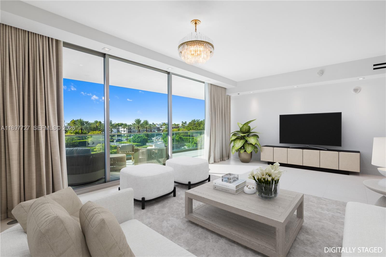 A digitally staged living room features floor-to-ceiling windows, a crystal chandelier, and a balcony view — 10201 Collins Ave # 311, Bal Harbour FL 33154, BAL HARBOUR, FL