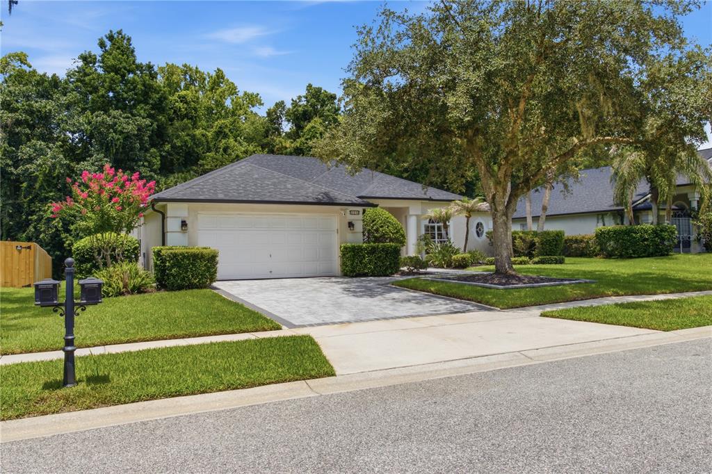 A single-story house with a paved driveway, a two-car garage, and a large front tree — 223 BLUE CREEK DRIVE, WINTER SPRINGS, FL