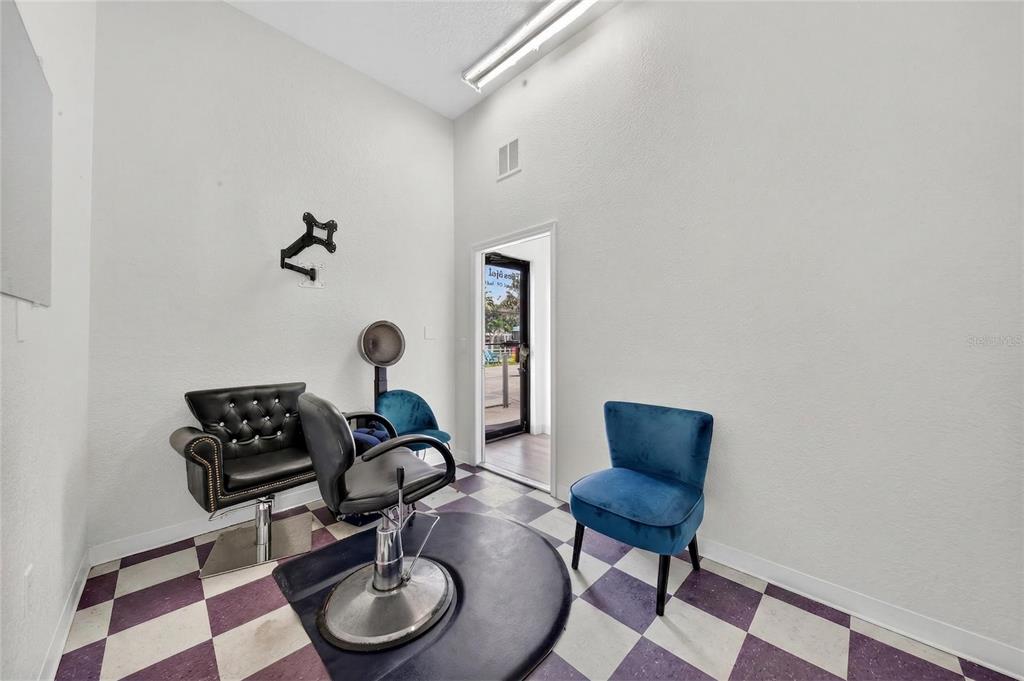 A salon room features a styling chair, a waiting chair, and a checkered floor — 595 9TH STREET UNIT 116, WINTER GARDEN, FL
