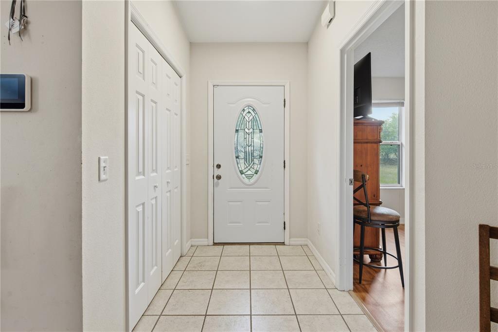 A tiled entryway features a white front door with a decorative oval glass insert — 16723 SE 173RD TERRACE ROAD, WEIRSDALE, FL
