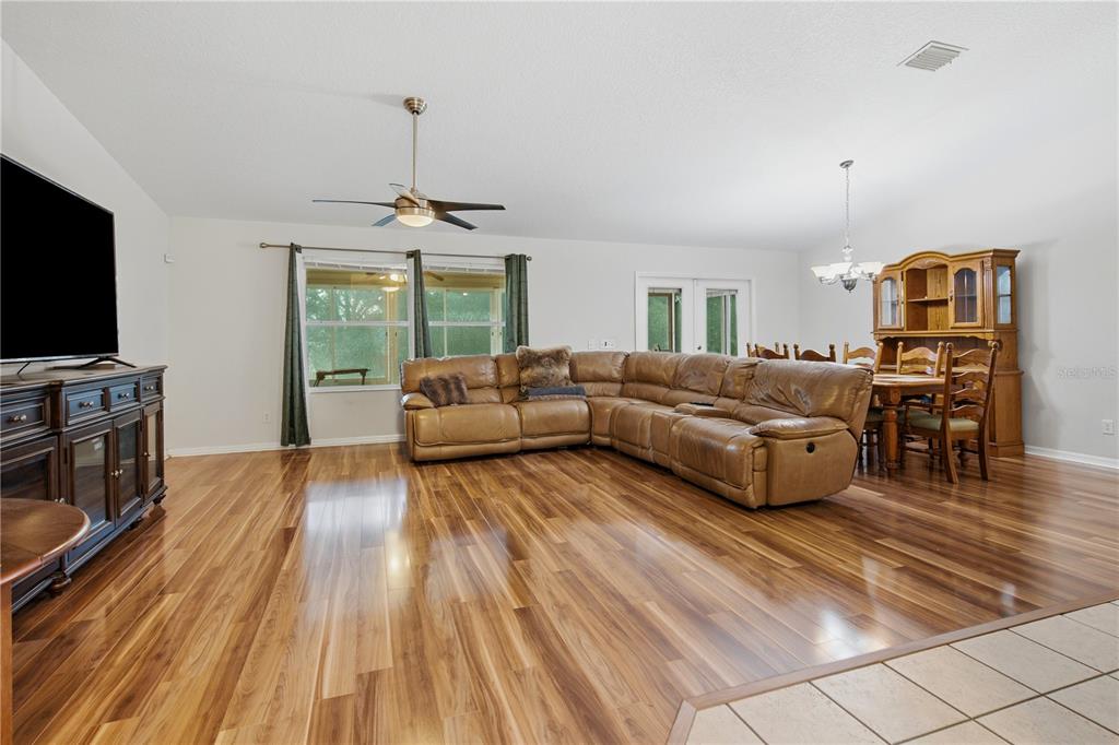 A living room features hardwood floors, a large sectional sofa, and a dining area — 16723 SE 173RD TERRACE ROAD, WEIRSDALE, FL