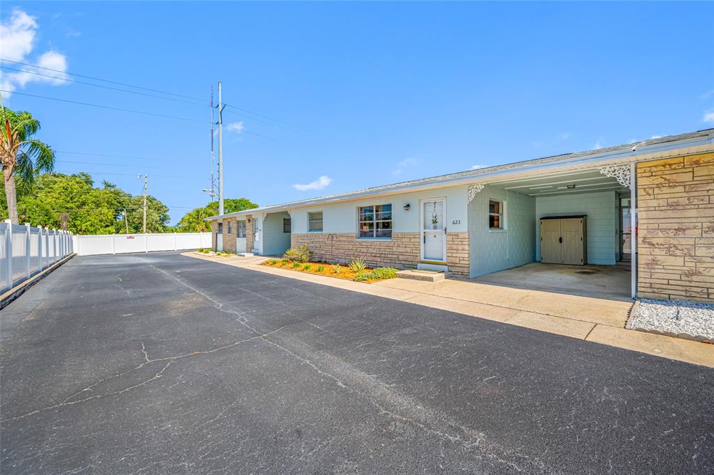 The exterior of a single-story building features a paved driveway, carport, and stone facade — 12400 PARK BLVD UNIT 623, SEMINOLE, FL