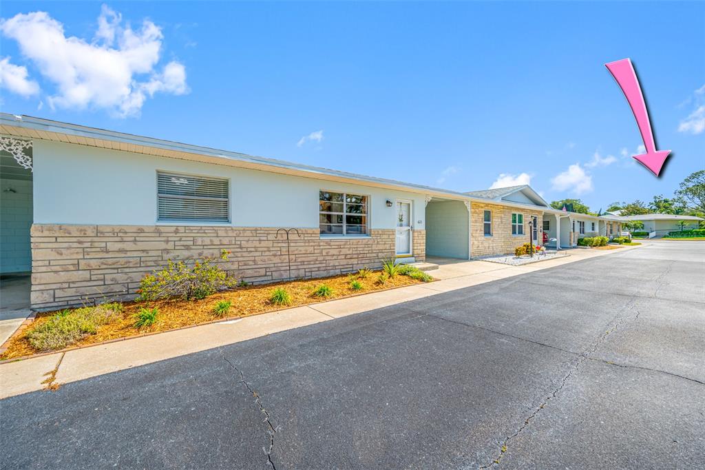 A single-story residential building with stone and light-colored siding features a covered carport area — 12400 PARK BLVD UNIT 623, SEMINOLE, FL