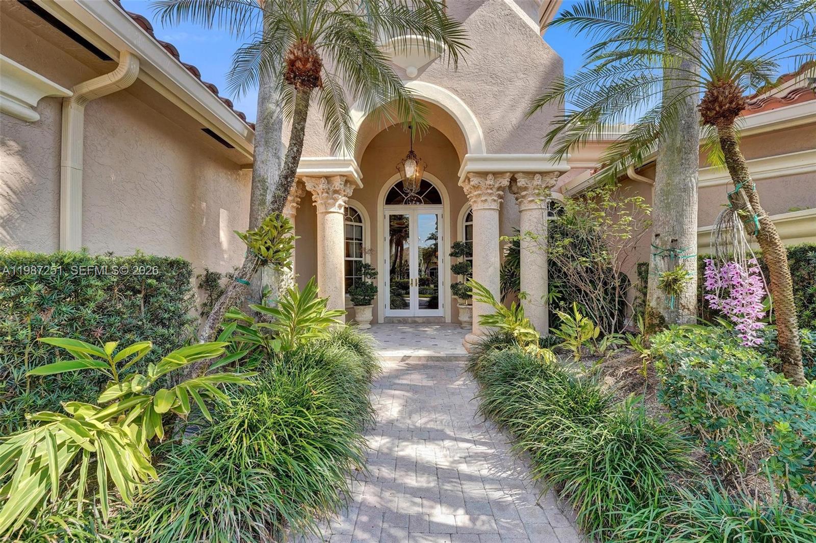 A stone walkway leads to the arched entryway of a house with decorative columns — 10813 Blackhawk St, Plantation FL 33324, PLANTATION, FL