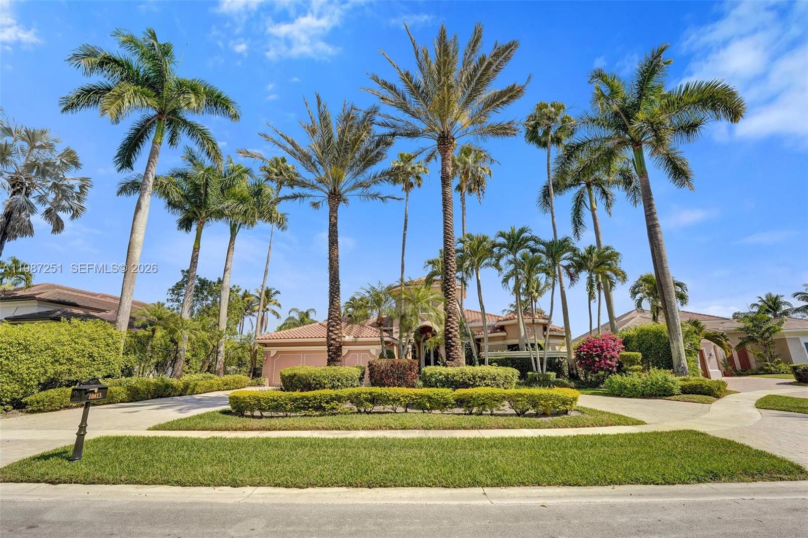 A single-story house with a tile roof is surrounded by numerous tall palm trees — 10813 Blackhawk St, Plantation FL 33324, PLANTATION, FL