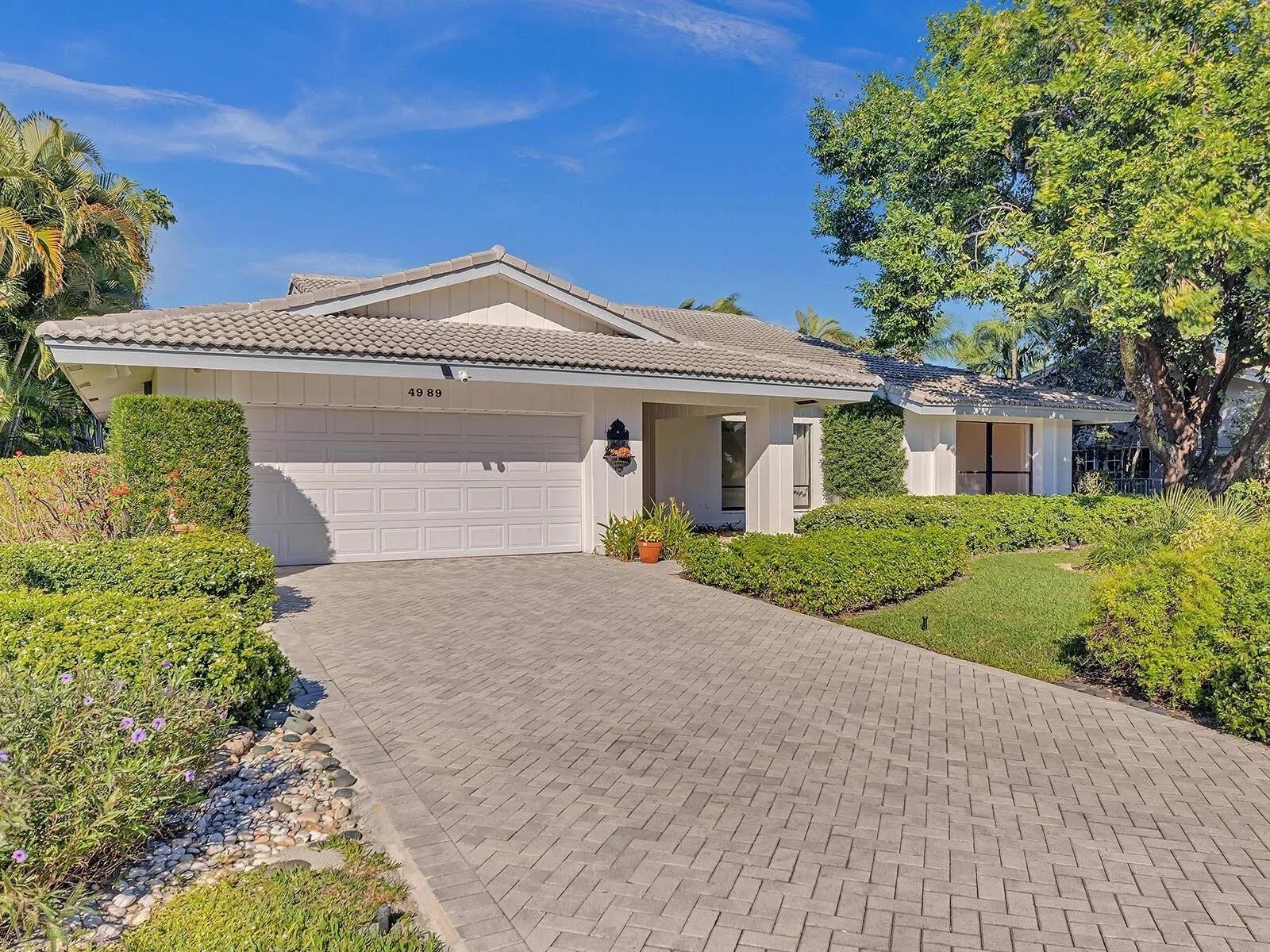 A single-story house with a white exterior, a tiled roof, and a paved driveway — 4989 Pineview Circle, Delray Beach FL 33445, DELRAY BEACH, FL