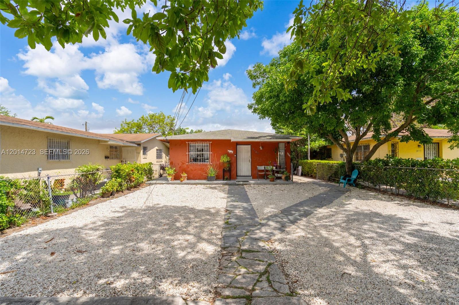 A single-story orange house with a gravel front yard and a stone walkway — 2385 NW 32nd St, Miami FL 33142, MIAMI, FL
