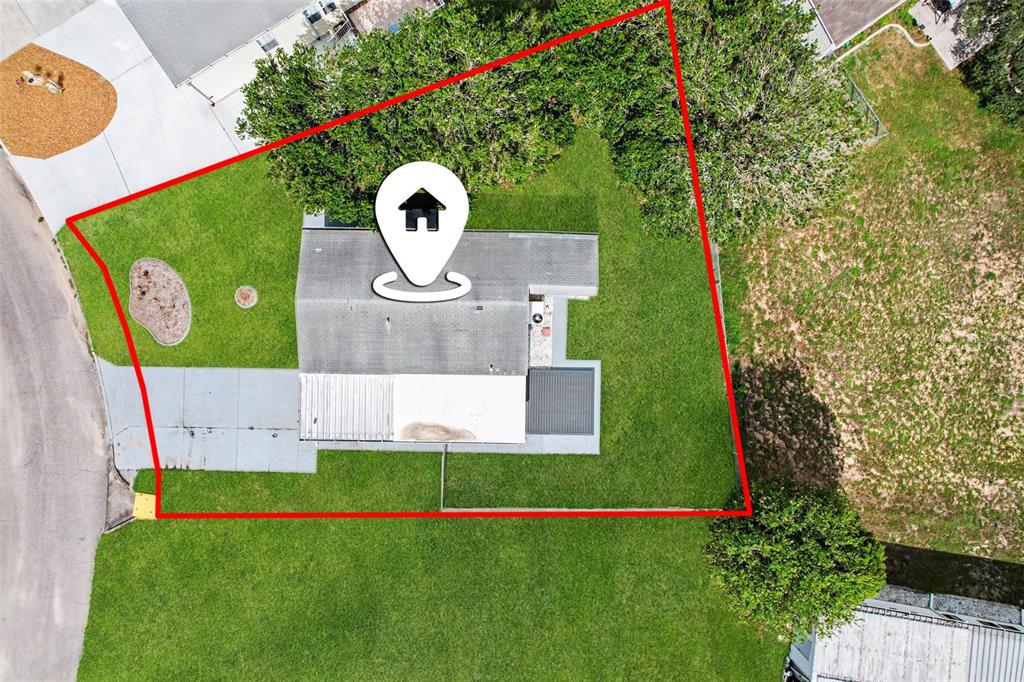 An aerial view shows a house with a gray roof situated on a grassy lot — 9213 SALISBURY DRIVE, BROOKSVILLE, FL