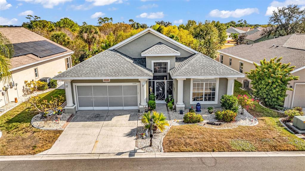 An aerial view of a single-story house with a two-car garage and landscaped front yard — 1644 PALACE COURT, PUNTA GORDA, FL