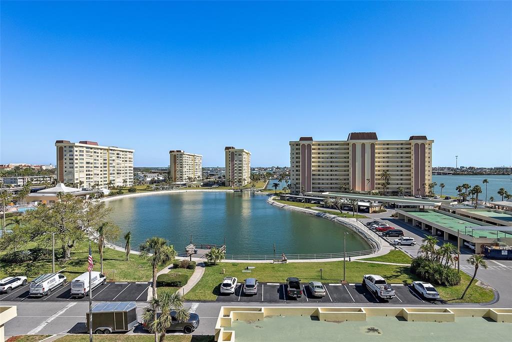 An elevated view shows a lagoon surrounded by apartment buildings and a parking lot — 4725 COVE CIRCLE UNIT 704, ST PETERSBURG, FL