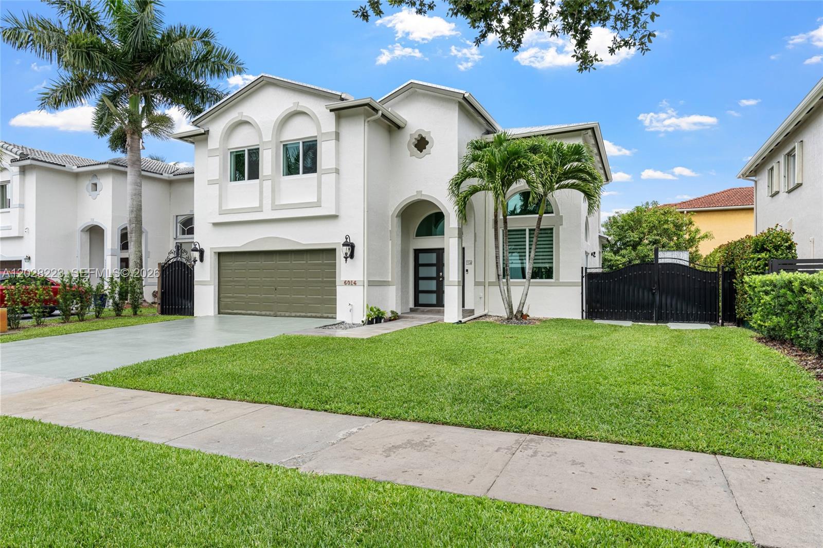A two-story white stucco house features a green garage door and a front lawn — 6014 SW 160th Ave, Miami FL 33193, MIAMI, FL