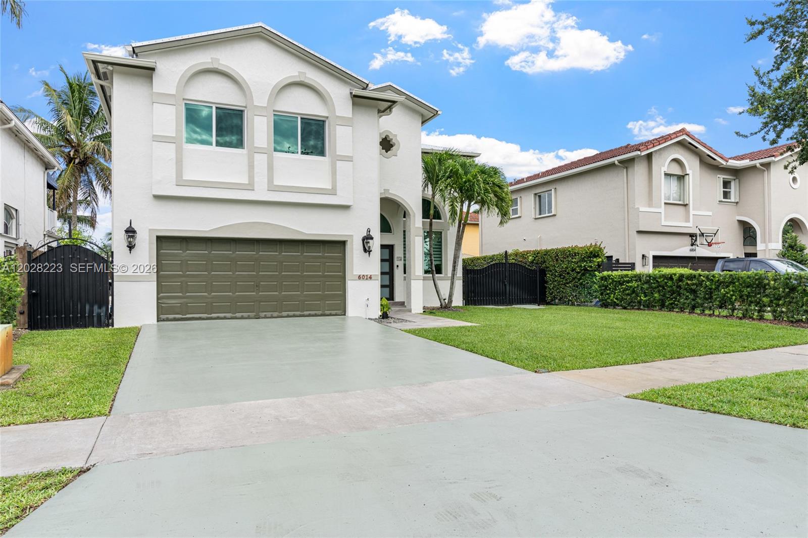 A two-story white house with a green garage door and a front lawn — 6014 SW 160th Ave, Miami FL 33193, MIAMI, FL