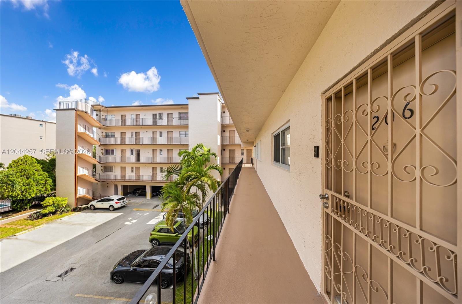 An exterior walkway leads to a unit door with a decorative metal security gate — 1950 W 54th St # 206, Hialeah FL 33012, HIALEAH, FL