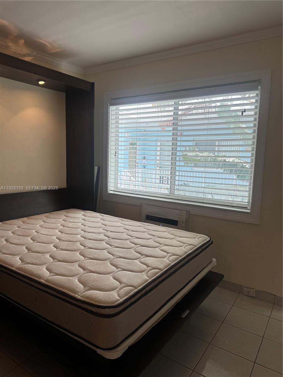 A bedroom features a dark wood Murphy bed frame, a mattress, and a window — 401 Collins Ave # 21, Miami Beach FL 33139, MIAMI BEACH, FL