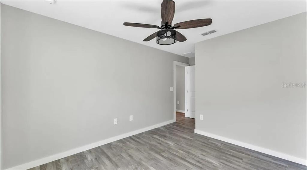 An empty room with light gray walls, wood-look flooring, and a ceiling fan — 0 38TH STREET NW, WINTER HAVEN, FL